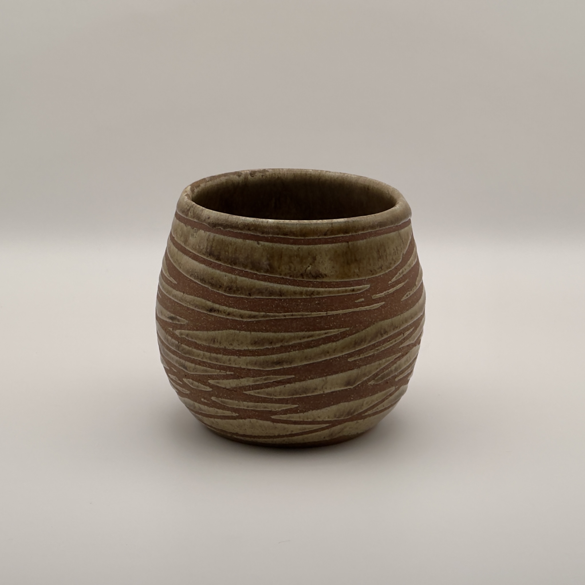 Brown round planter with a linear carved texture