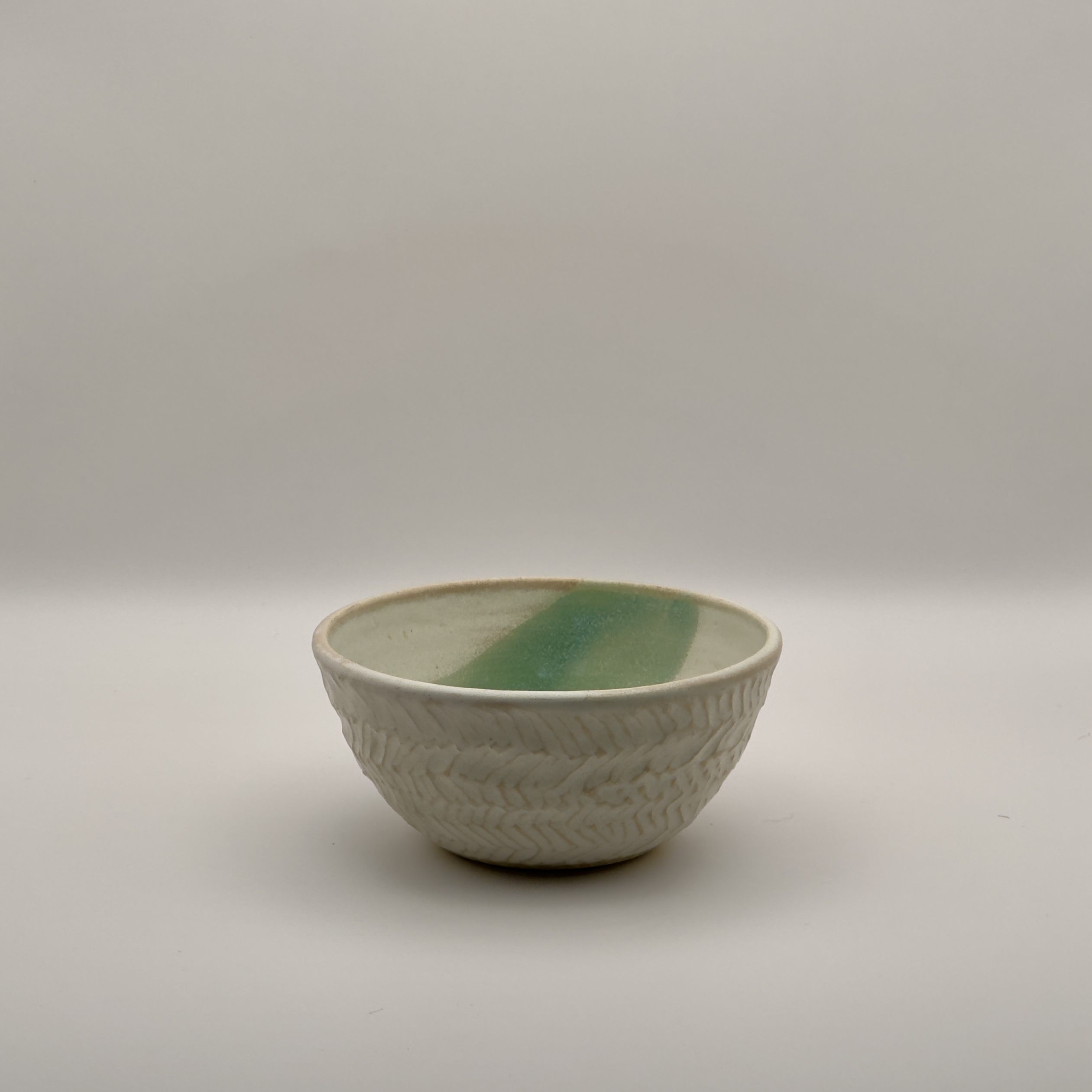 White textured bowl with a green brushstroke pattern