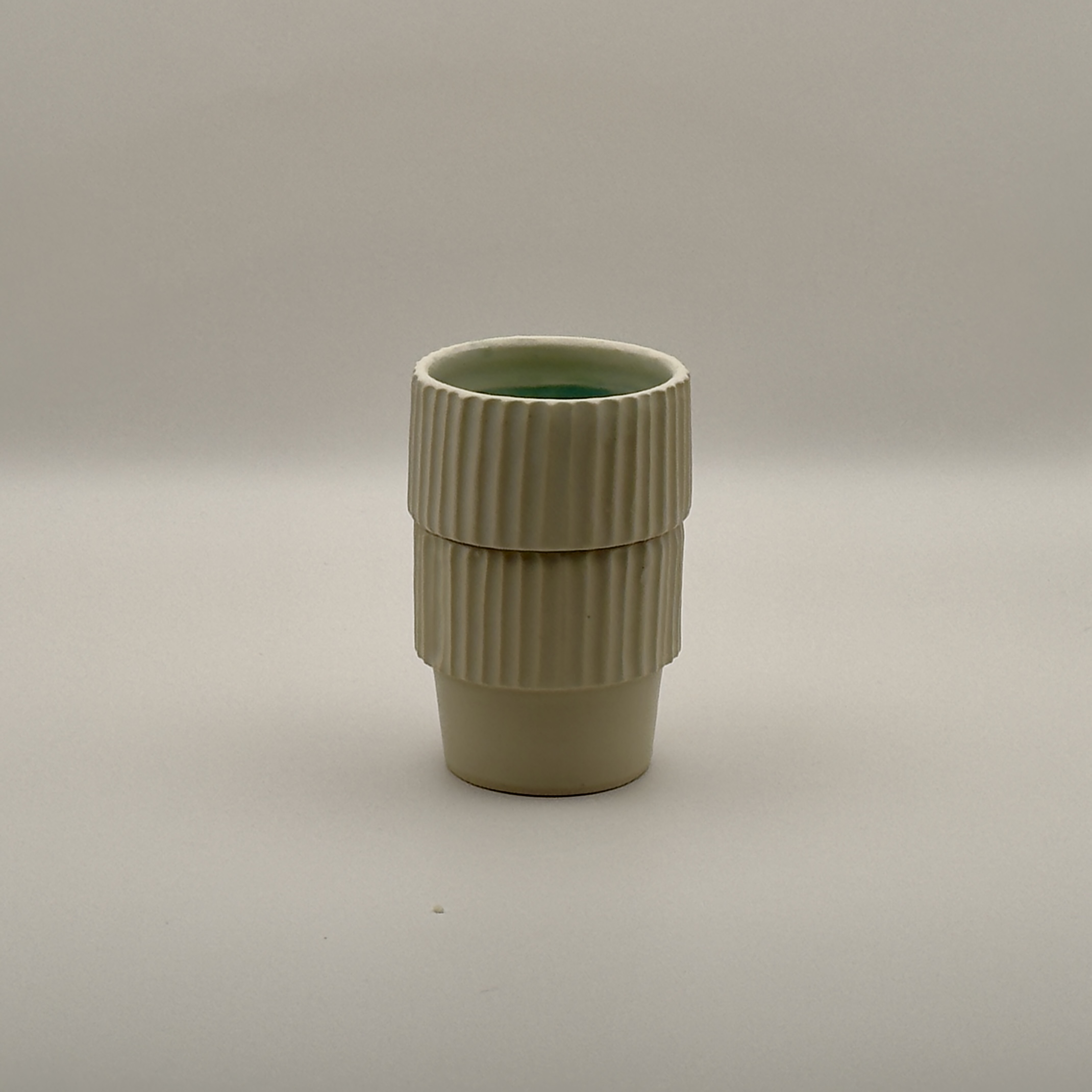 Tall ribbed cream tumbler with a wide textured band