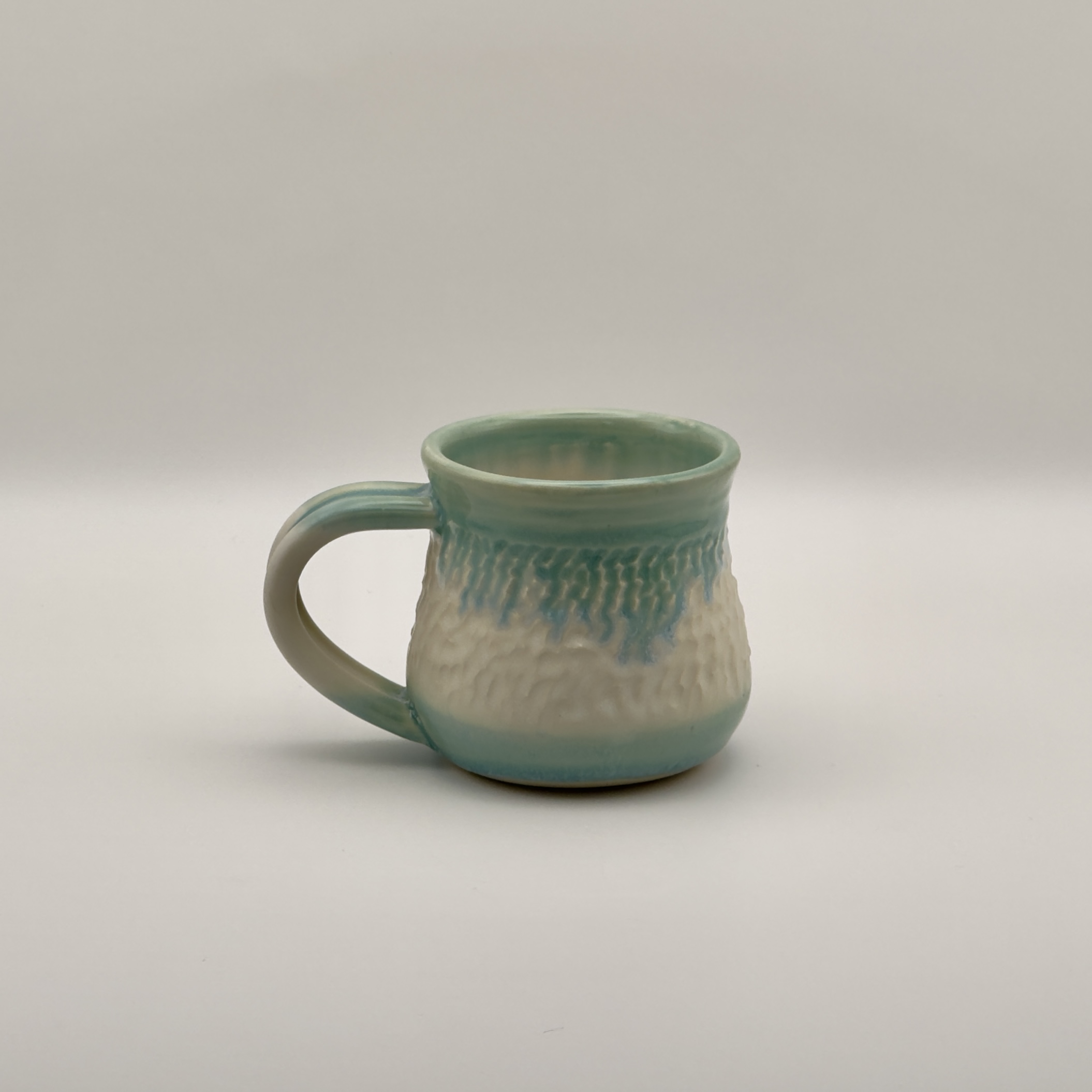 Seafoam green mug with a drippy white glaze