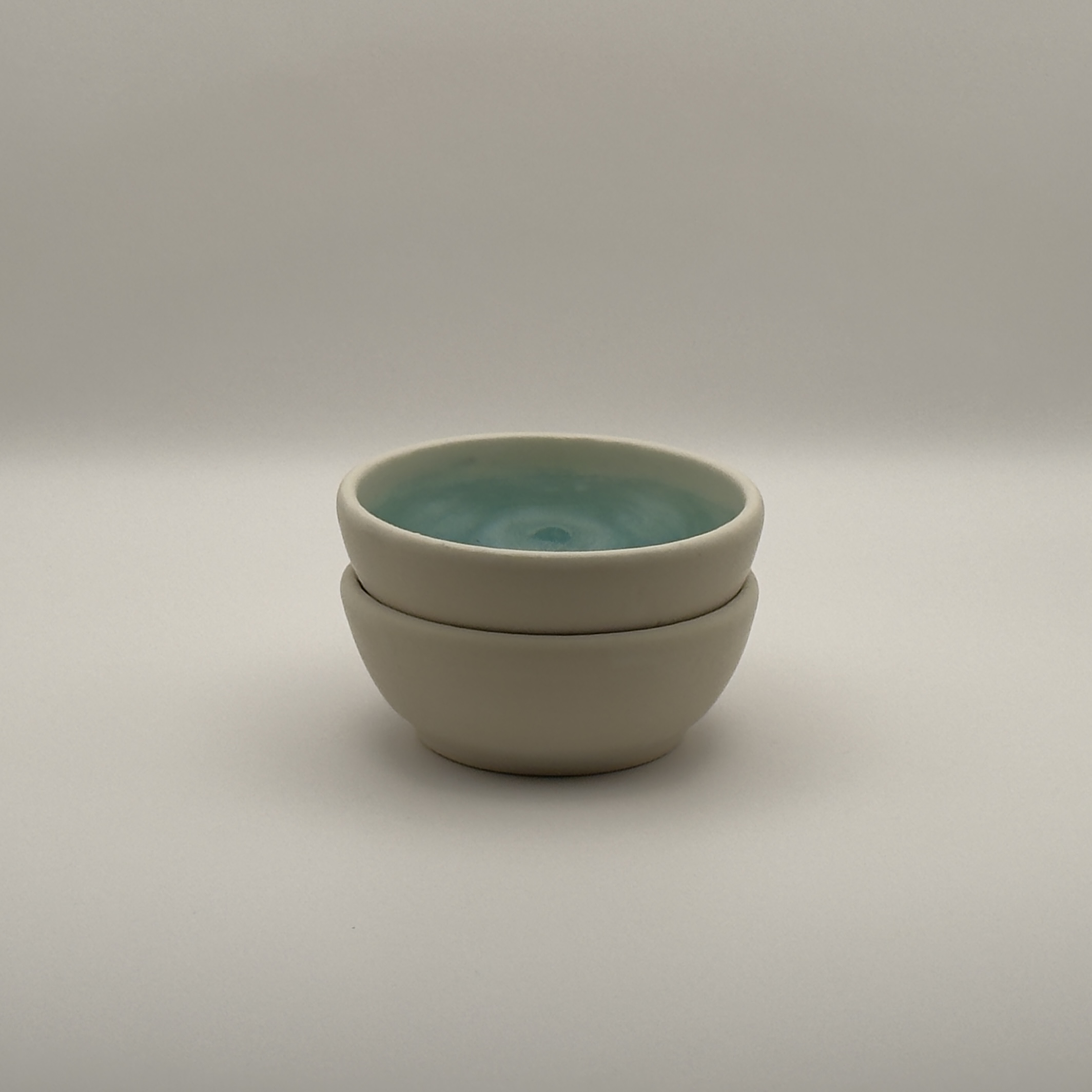 Two stacked small cream bowls
