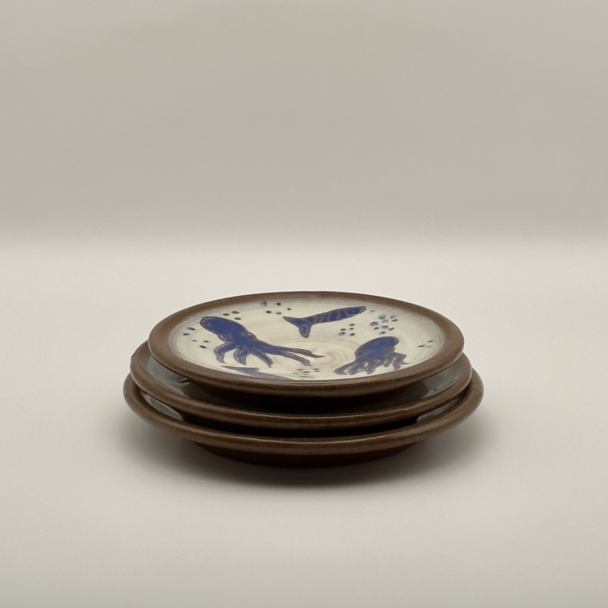 Stack of plates with a blue fish and squid design